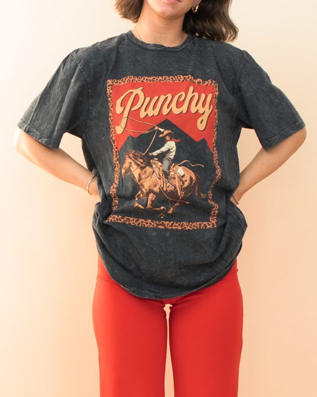 black graphic tee with a cowboy riding a horse, styled with a red pant