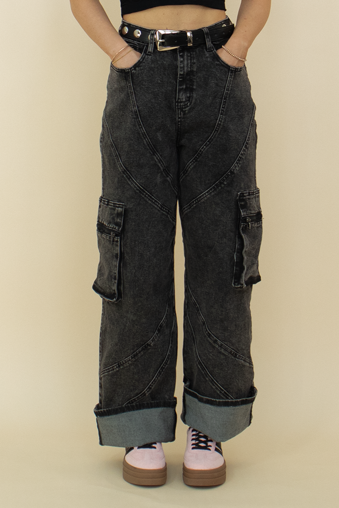 black cargo jean in a zoomed in view to show the seam detailing, styled with pink sneakers