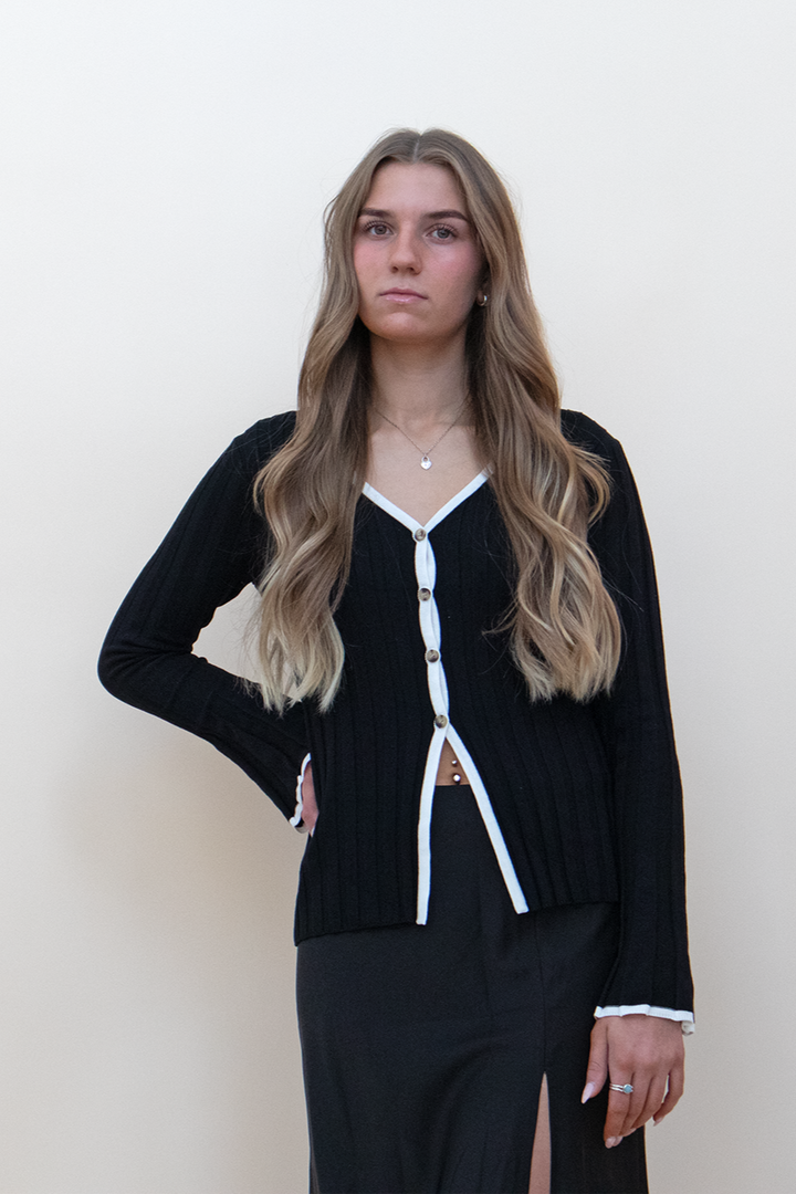 black bell sleeve button up top with white line detailing, styled with a black skirt