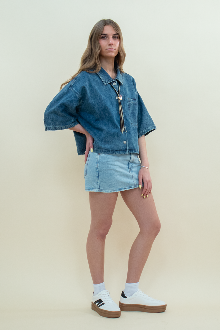 Groove Closet model wearing an oversized denim jacket paired with a light wash denim mini skirt and sneakers. Casual women’s denim outfit for streetwear and everyday fashion.