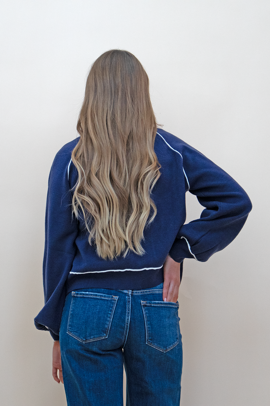Navy blue cardigan with bishop sleeve as seen from the back, styled with a dark blue jean.