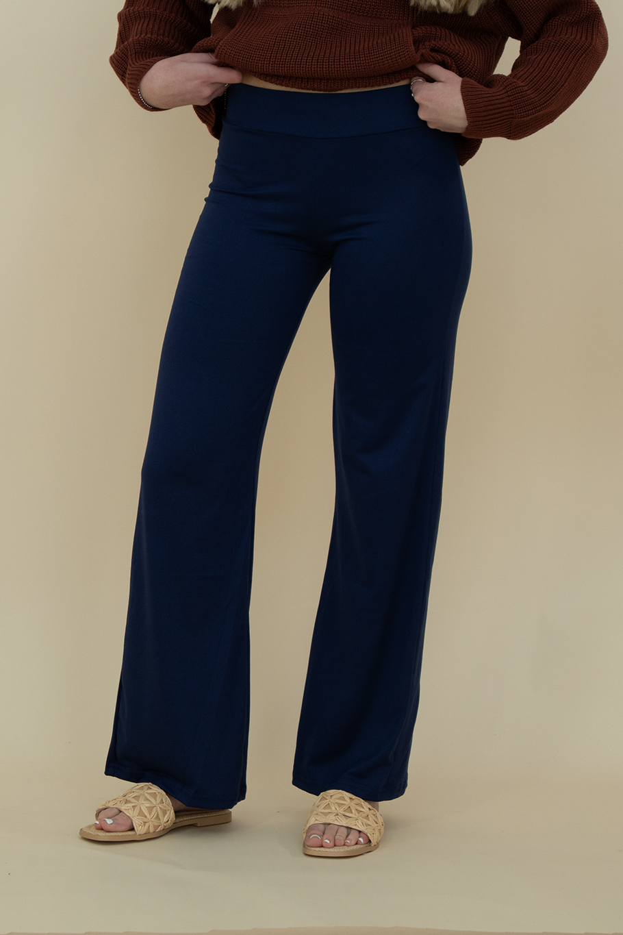 Close-up front view of navy blue flare pants with smooth stretch fabric and high-waisted fit, styled for comfort and versatility.