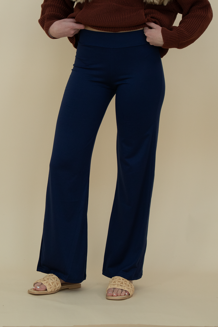 Close-up front view of navy blue flare pants with smooth stretch fabric and high-waisted fit, styled for comfort and versatility.