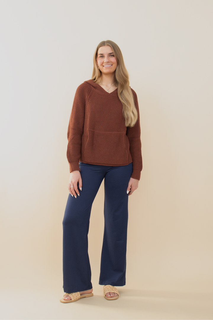 Trendy fall fashion outfit featuring wide-leg navy pants with cheetah star detail and a cozy oversized brown sweater, modeled against a soft beige backdrop.