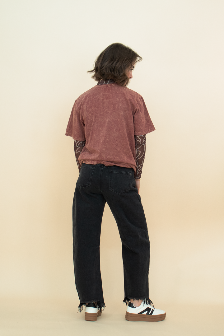 red-brown acid wash graphic tee as seen from the back, styled with a black jean and a white sneaker
