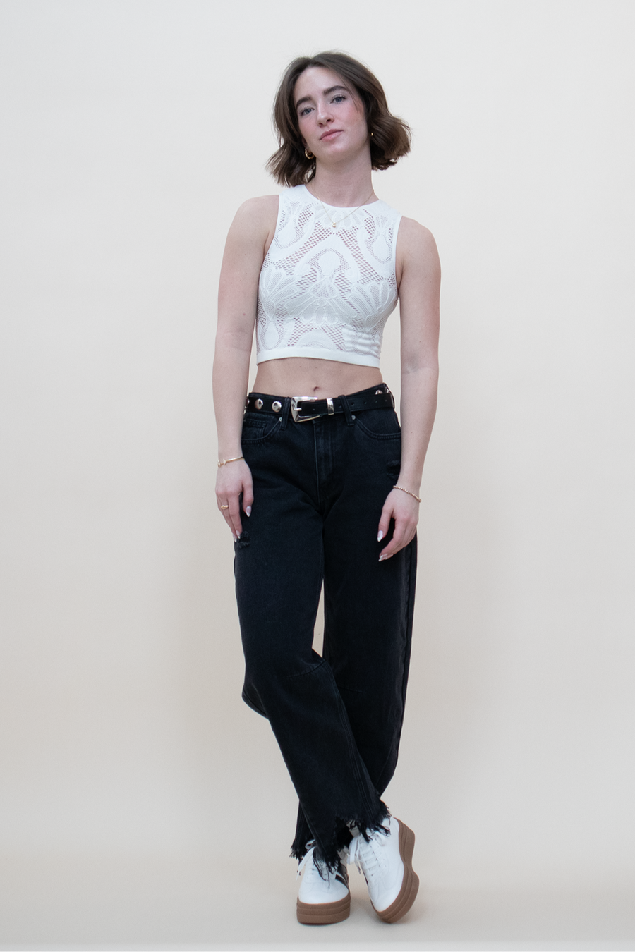 white cropped nylon fishnet tanktop with a shell pattern, paired with black barrel jeans, white sneakers and a black belt with silver studs