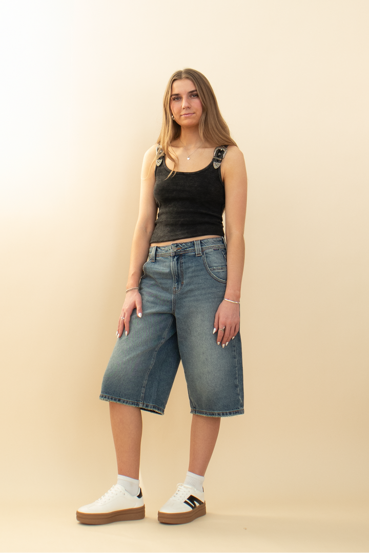wide leg denim jort styled with white sneakers and a black tank top
