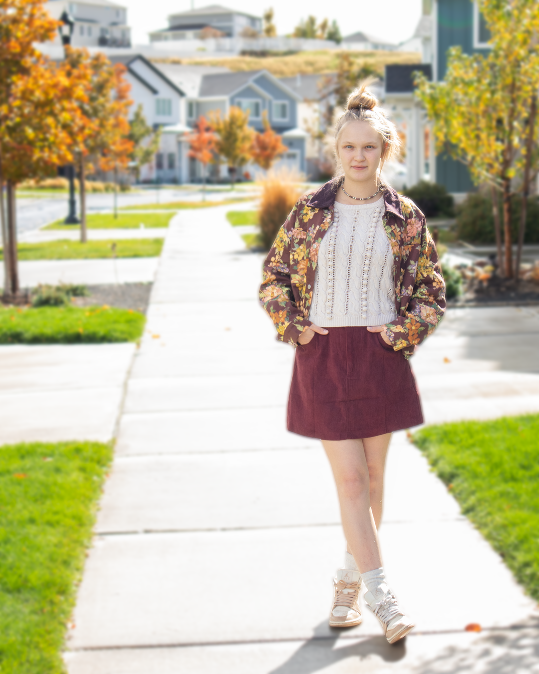 Full outfit view of a maroon floral jacket with corduroy collar and relaxed silhouette, styled with a cream knit top and burgundy skirt.