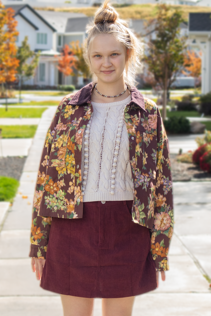 Front view of a maroon floral jacket with brown corduroy collar, oversized floral print, chest pockets, and relaxed fit.